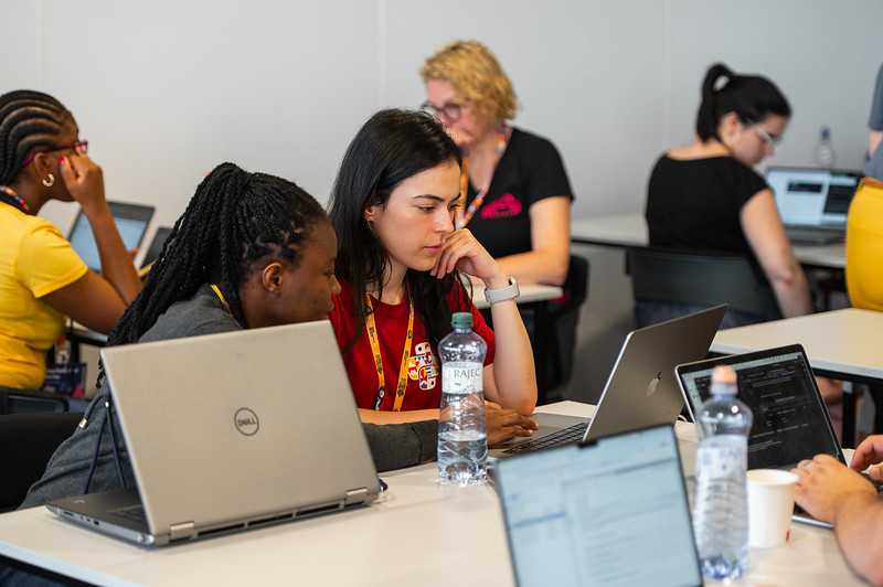 A group of people working and collaborating on computers during a workshop